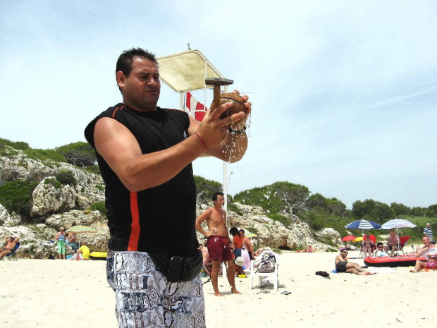 Calas de Mallorca - sprzedawca owoców na plaży. Przesympatyczny człowiek :) Chciałyśmy kokosa i Pan z odpowiednim narzędziem w dłoni szykuje się do jego rozbicia #Majorka #CalasDeMallorca