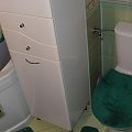 łazienka/toaleta - kompakt WC Koło częściowo ukryty za szafką stojącą; u góry częściowo widoczna klapka na licznik wody i zawór główny